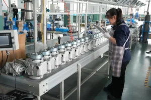 Picture showing a female worker is checking with a row of ACTECmax compressors